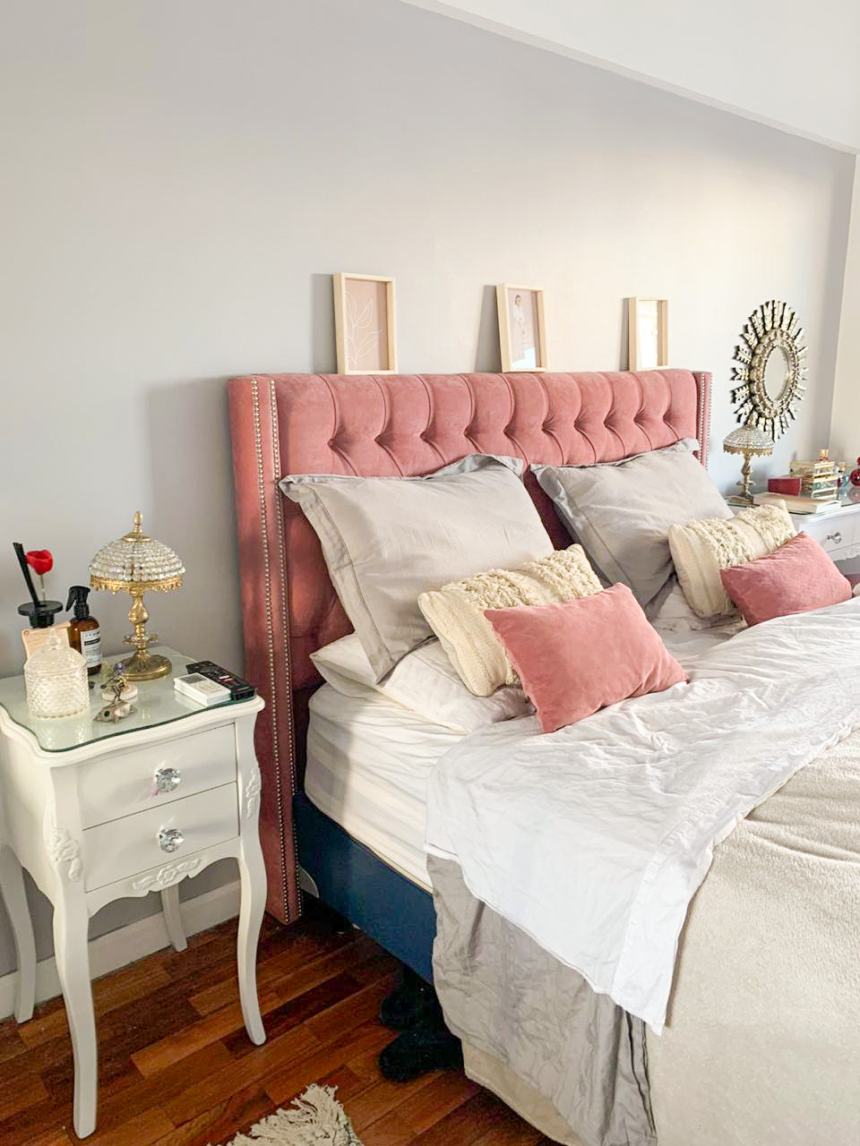 Respaldo Emmy rosa con mesa de luz blanca y lámpara en el dormitorio