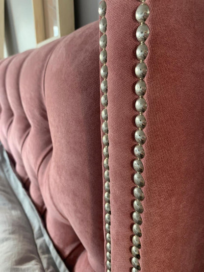 Detalle de las tachas plateadas en el borde de la oreja del Respaldo Emmy rosa
