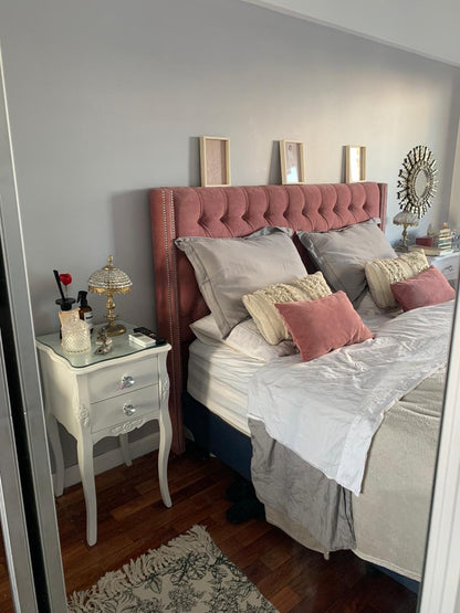 Dormitorio completo con el Respaldo Emmy rosa, mesas de luz blancas y alfombra