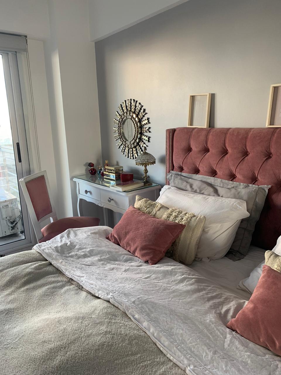 Dormitorio con ventana, tocador blanco y Respaldo Emmy rosa con tachas