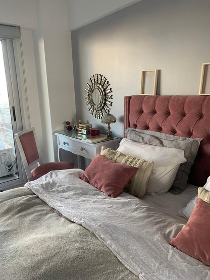 Dormitorio con ventana, tocador blanco y Respaldo Emmy rosa con tachas