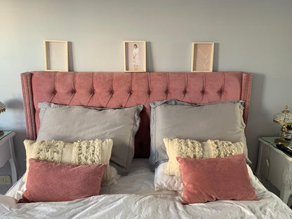 Vista frontal del Respaldo Emmy rosa con almohadones grises, crudos y rosa