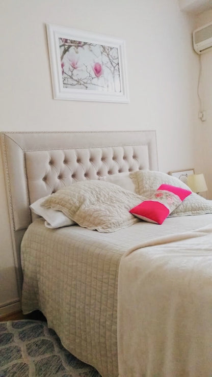 Cama con el Respaldo Grace beige y tachas plateadas, vista desde los pies, en el dormitorio de Estefanía