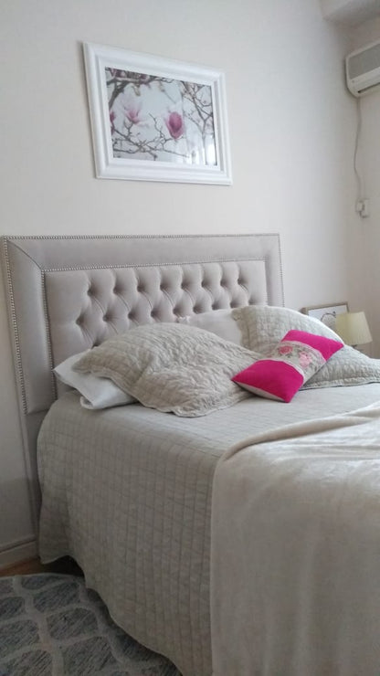 Respaldo Grace beige con tachas plateadas en el dormitorio luminoso de Estefanía