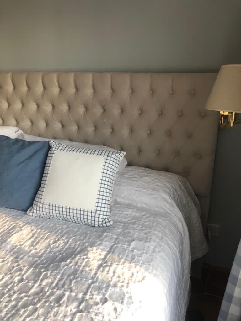 Detalle del capitoné en diamante del Respaldo Mily beige de Josefina, junto al aplique dorado de pared