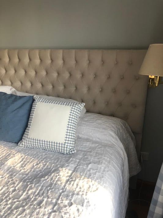 Detalle del capitoné en diamante del Respaldo Mily beige de Josefina, junto al aplique dorado de pared
