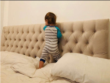 Respaldo Mily beige con capitoné en diamante en el dormitorio de Josefina, con su hijo León parado sobre la cama