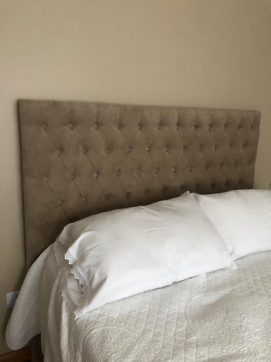 Respaldo Mily beige con capitoné de botones en toda la superficie y sin marco, detrás de una cama con ropa blanca en el dormitorio de Guillermina