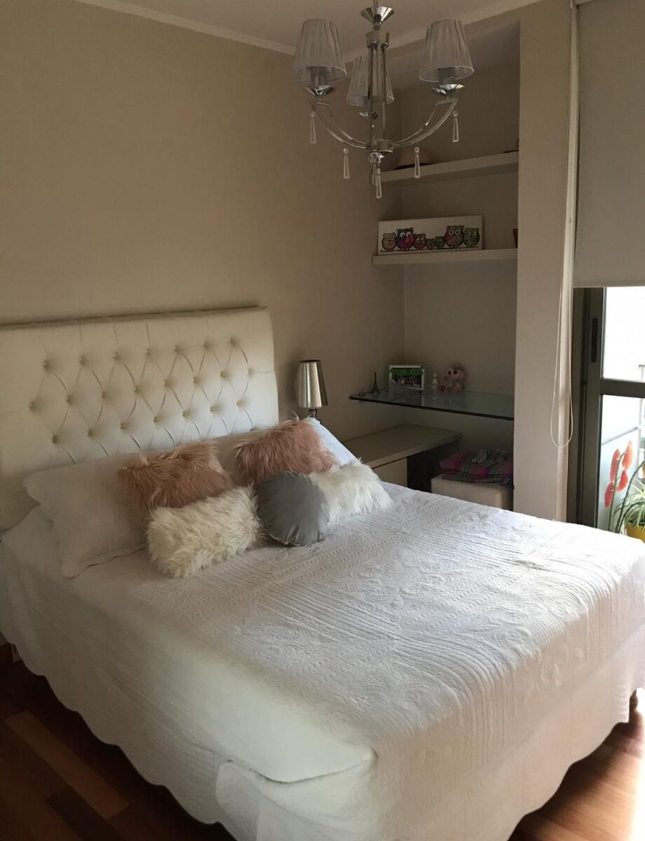 Respaldo Mily blanco con capitoné de borde a borde, en el dormitorio de Cielo, bajo un chandelier de cristal con lágrimas