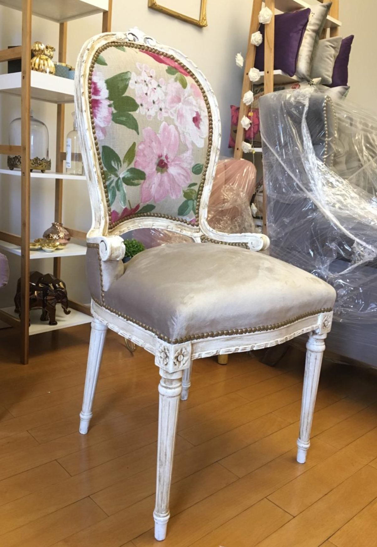 Silla de estilo con pátina blanca envejecida, respaldo ovalado tapizado en género floral y asiento en terciopelo gris, retapizada en la fábrica