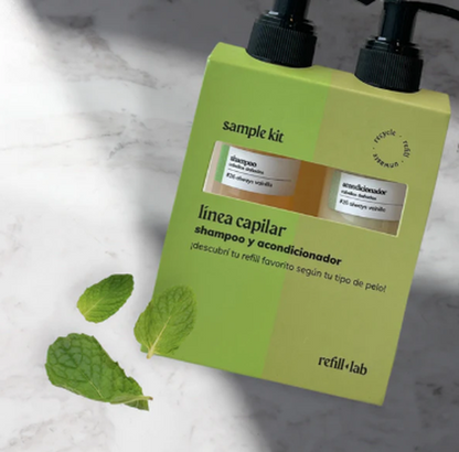 Caja verde del Sample Kit Capilar Refill Lab en diagonal, con hojas de menta sobre mármol