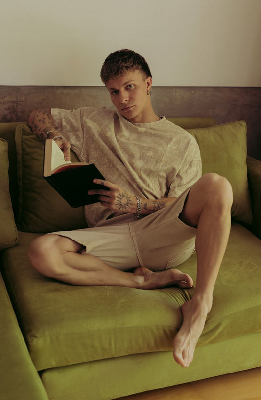 Santiago Colinet leyendo un libro, sentado en su Sillón Esquinero Richard de terciopelo verde