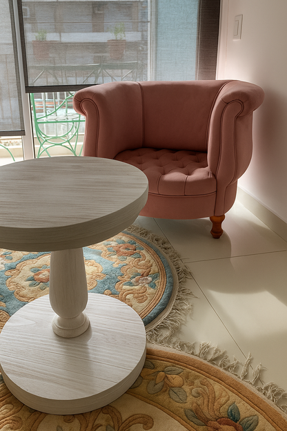 Un sillón tapizado en pana rosa de diseño redondeado, con apoyabrazos curvos y patas de madera, que aporta un aire elegante y acogedor al ambiente."