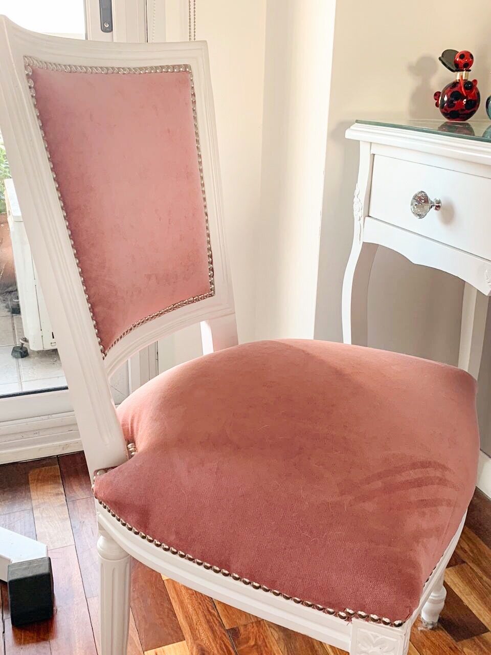 Silla a medida de estilo francés laqueada en blanco, con tapizado rosa y tachas, en la casa de Evelyn
