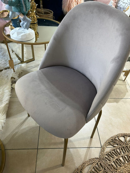 Silla Estrella en pana gris en un living, con el respaldo curvo que envuelve el asiento