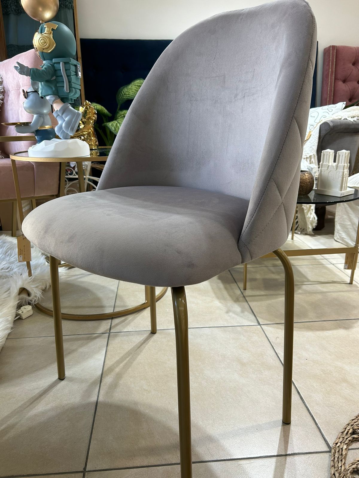 Silla Estrella en pana gris de frente, con asiento acolchado y patas metálicas doradas