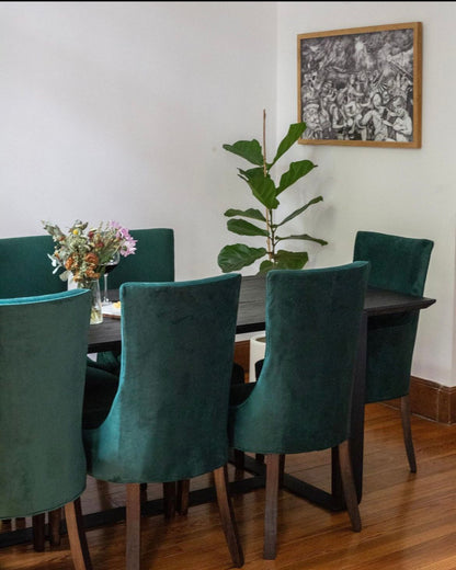 Comedor de San Telmo con Sillas Amalfi verdes, una planta y un cuadro en blanco y negro, proyecto de WN Interiores