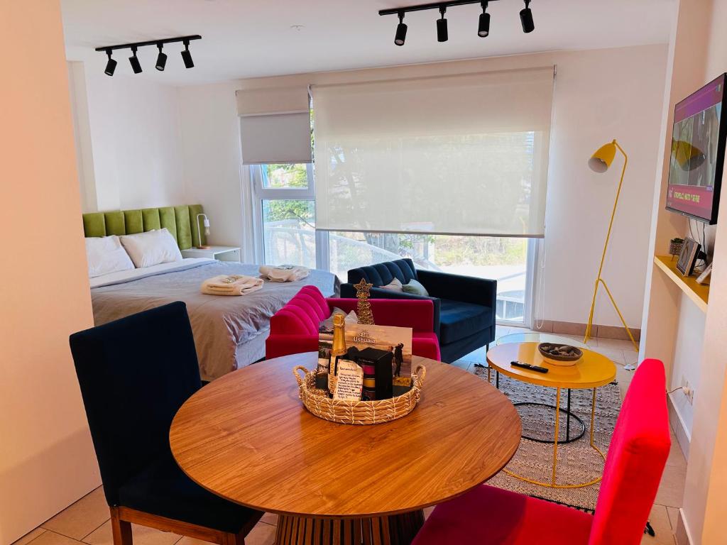 Sillas Deli azul y roja alrededor de una mesa redonda de madera, en un departamento de Austral Rental en Ushuaia