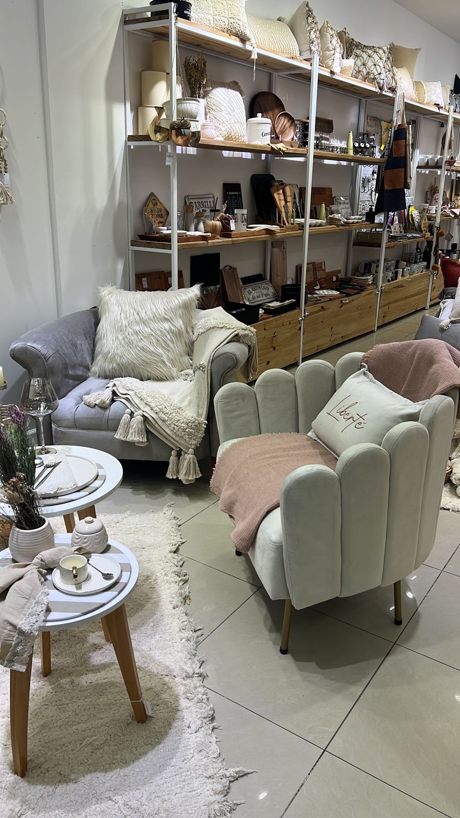Sillón Angie blanco con respaldo de pétalos y patas doradas junto a un Sillón Brigitte gris, en Darilo's Store, Shopping Portal de la Patagonia, Neuquén