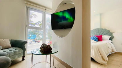 Vista completa del ambiente: sillón Brigitte celeste junto al ventanal y, del otro lado del tabique, la cama con el respaldo Ostras