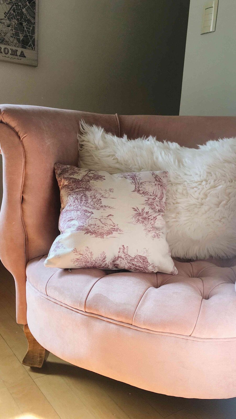 Sillón Brigitte rosa con apoyabrazos enrollados y asiento capitoné, con almohadones, en el rincón de lectura de Evelyn