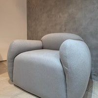 Sillón Cabsha de bouclé gris perla con formas curvas, en stock con entrega inmediata