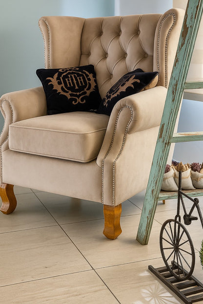 Sillón Elepant beige con capitoné y tachas en los brazos, en la casa de una clienta