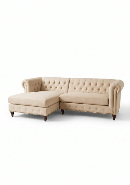 Sillón esquinero Chesterfield en pana antimanchas Latte, con chaise, capitoné y tachas sobre fondo blanco