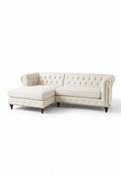 Sillón esquinero Chesterfield en pana antimanchas Tiza, con chaise, capitoné y tachas sobre fondo blanco