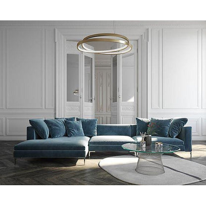 Sillón esquinero Florence en azul sobre piso de madera en espiga, con almohadones decorativos y chaise longue