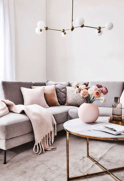 Sillón esquinero gris moderno con cojines rosas y estantería – Tienda de Banquitos Argentina