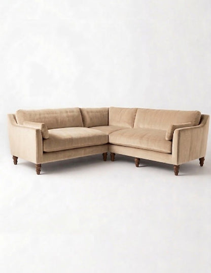Sillón esquinero Leonelle en pana antimanchas Latte, forma en L, almohadones y patas torneadas de madera
