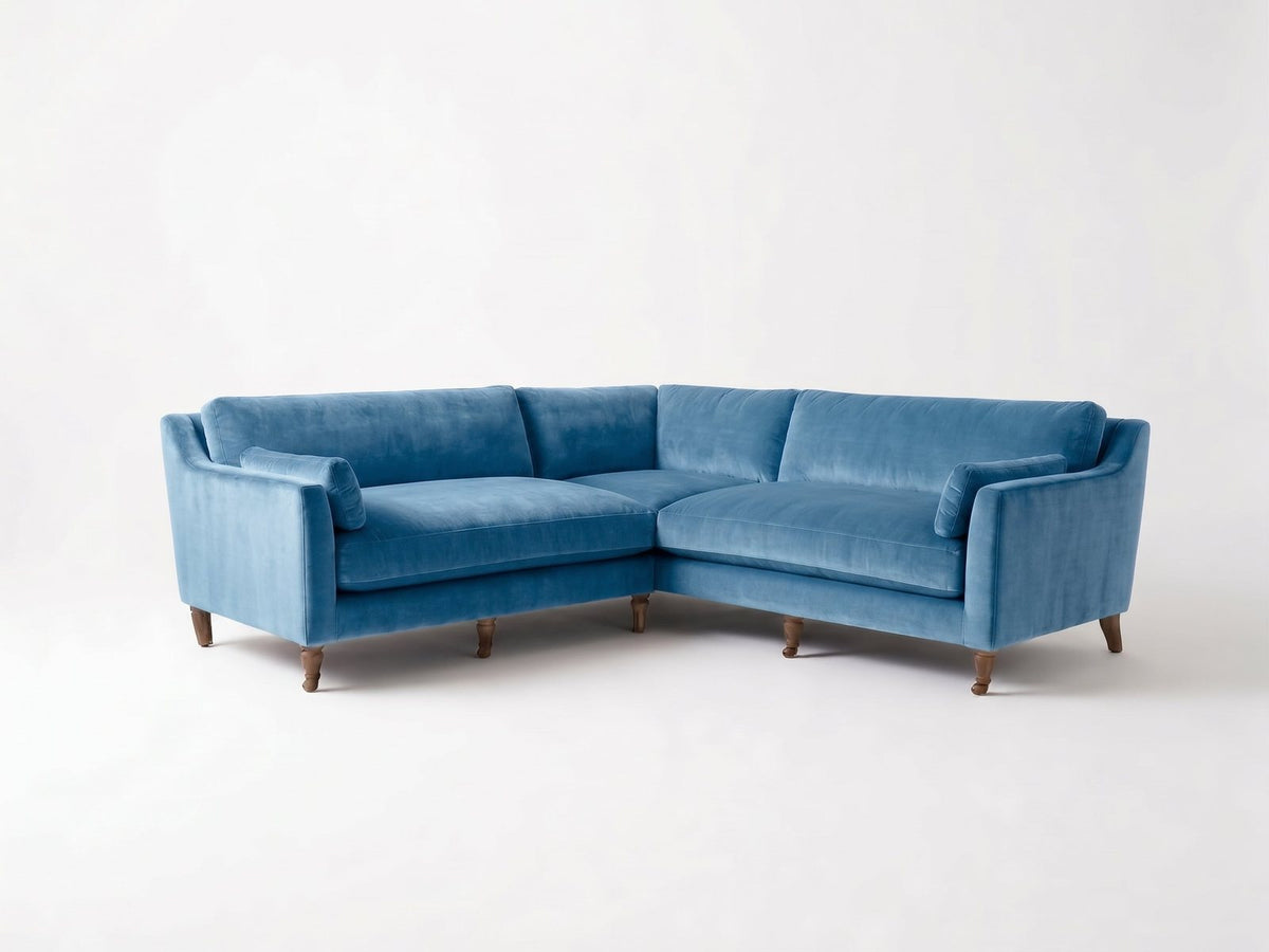 Sillón esquinero Leonelle en pana antimanchas Océano, forma en L, almohadones y patas torneadas de madera