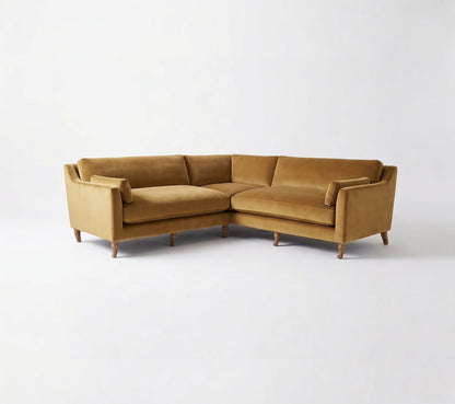 Sillón esquinero Leonelle en pana antimanchas Oro, forma en L, almohadones y patas torneadas de madera