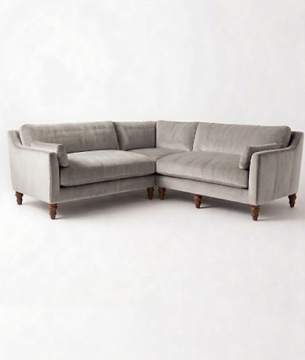 Sillón esquinero Leonelle en pana antimanchas Plata, forma en L, almohadones y patas torneadas de madera