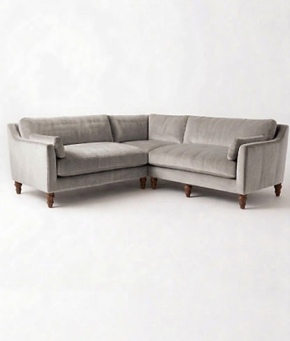 Sillón esquinero Leonelle en pana antimanchas Plata, forma en L, almohadones y patas torneadas de madera