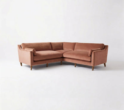 Sillón esquinero Leonelle en pana antimanchas Rosa, forma en L, almohadones y patas torneadas de madera