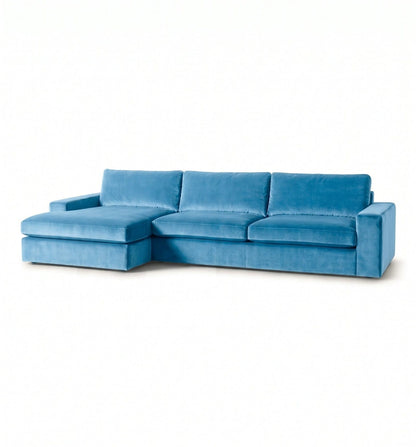 Sillón esquinero Victoria en pana antimanchas celeste, forma en L con chaise, brazos rectos y almohadones grandes