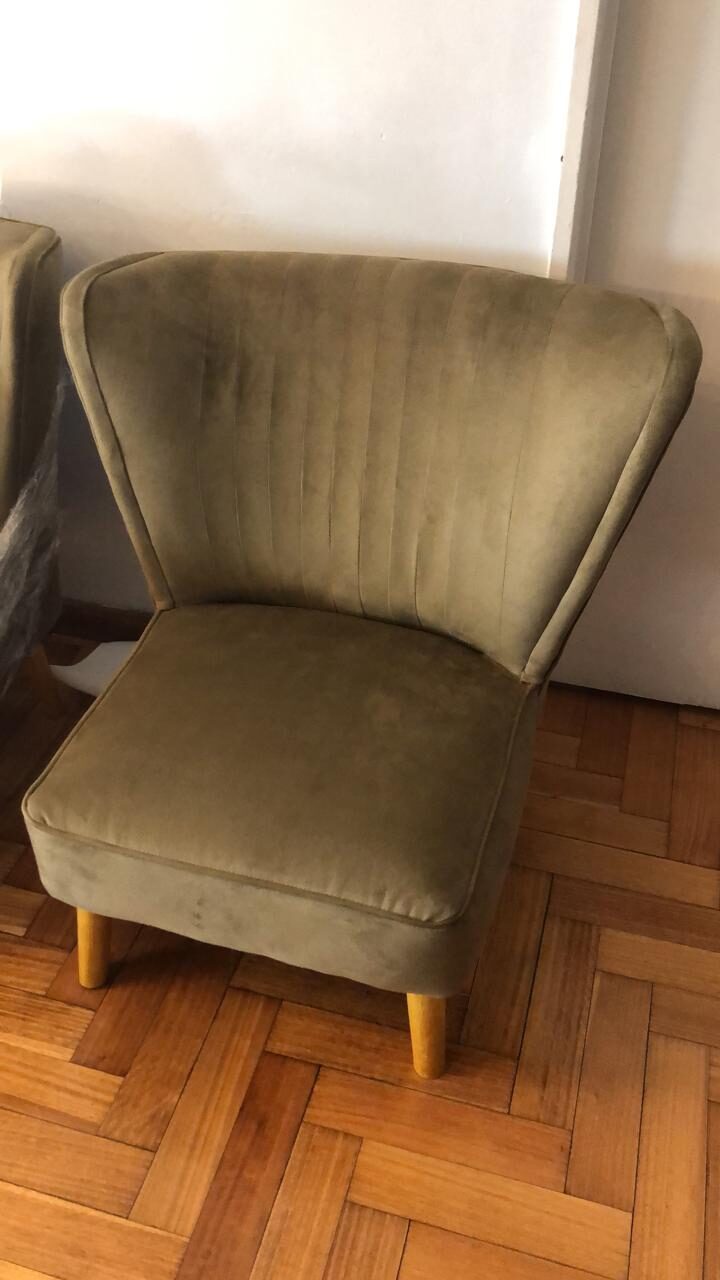 Sillón Matero Tita en verde oliva, con respaldo en abanico de canales verticales y patas de madera, sobre el parquet de la casa de Yésica