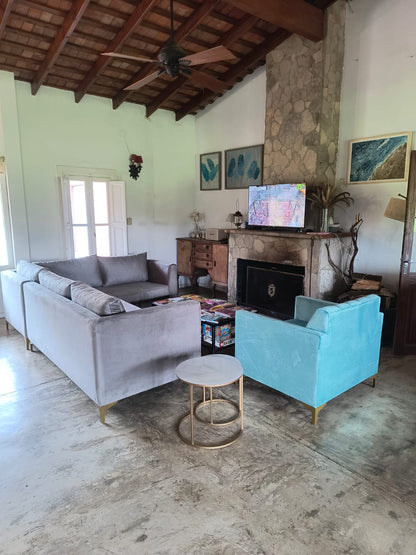 Sillón Mila turquesa junto al Esquinero Magnolia gris en un living con techo de vigas de madera