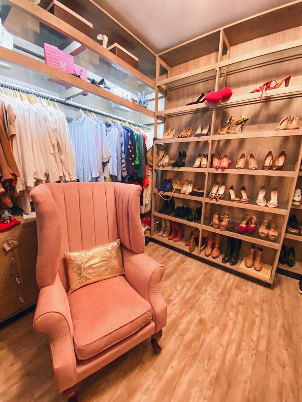 Sillón Mortisia rosa de respaldo alto acanalado, junto al zapatero dorado del vestidor de Carolina