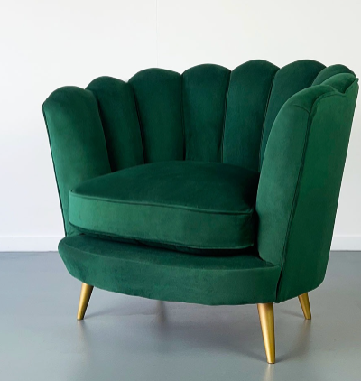 Sillón Florencia de un cuerpo en ambiente cálido, junto a cortinas de lino y mesa ratona de madera clara, tapizado en tono crudo, respaldo curvo y almohadón decorativo