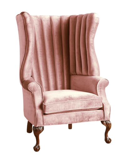 Sillón individual tapizado en rosa, con respaldo alto acanalado de líneas verticales, brazos curvos y patas delanteras torneadas con ruedas pequeñas.
