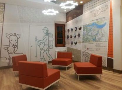 Sillones Janod rojos en una sala de espera con ilustraciones en la pared