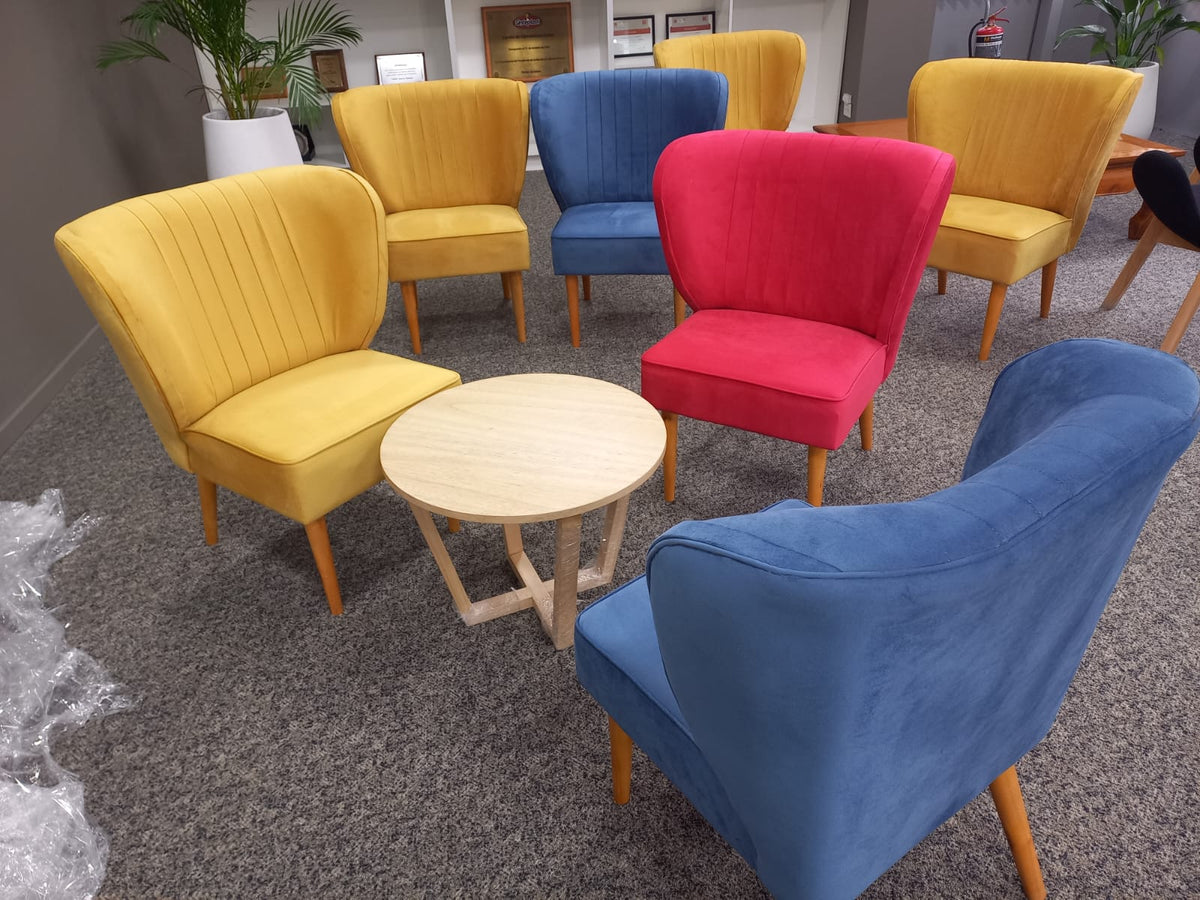 Sillones Matero Tita en amarillo, azul y fucsia con respaldo en canales y patas de madera, en las oficinas de Sinteplast
