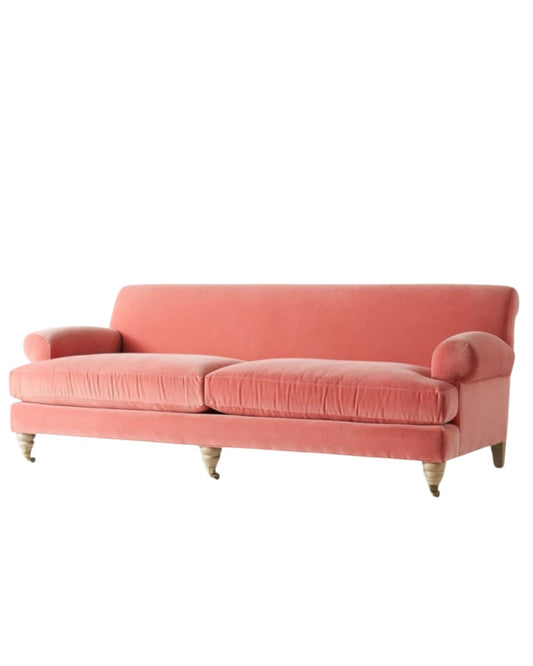Sofá Cecily tapizado en velvet coral, con brazos redondeados y patas torneadas con rueditas - Tienda de Banquitos