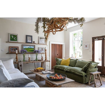 Sofá Comfy verde con funda de tussor en un living amplio con mesa ratona de madera - Tienda de Banquitos
