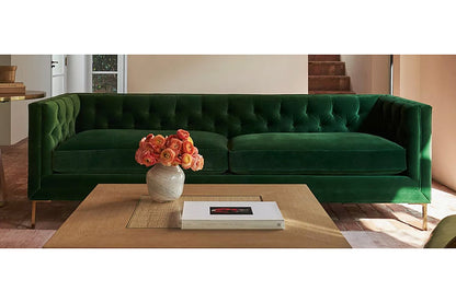 Sofá Dior en pana verde con capitoné y patas de metal doradas, ambientado en living - Tienda de Banquitos