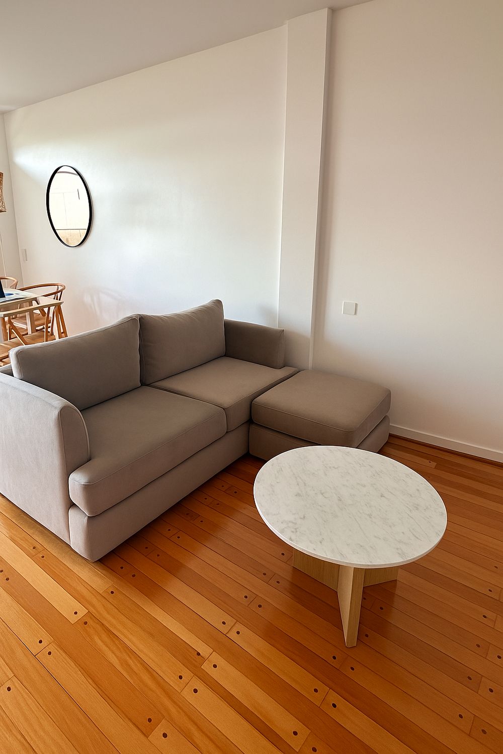 Sofá Elton beige con puff al tono y mesa ratona de mármol, en el living de Verónica