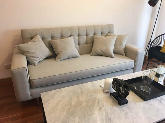 Sofá gris beige moderno tufted con mesa de mármol en living - diseño Argentina